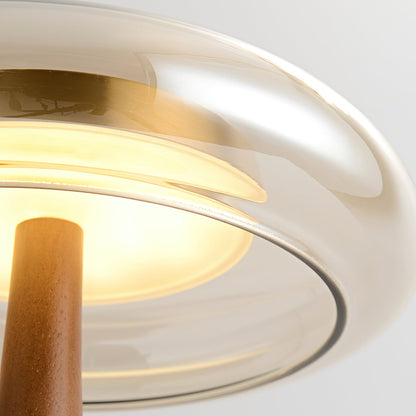 De Pirevo glazen tafellamp is een verfijnde combinatie van glas, messing en hout