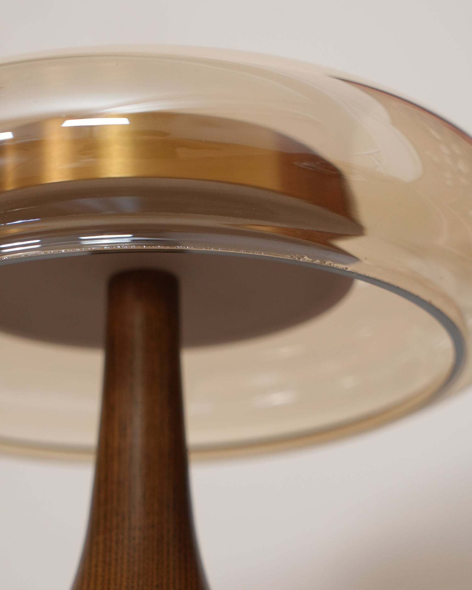 De Pirevo glazen tafellamp is een verfijnde combinatie van glas, messing en hout