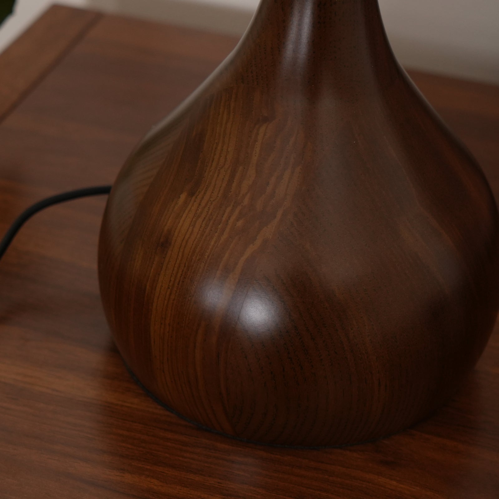 De Pirevo glazen tafellamp is een verfijnde combinatie van glas, messing en hout