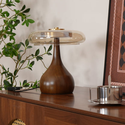 De Pirevo glazen tafellamp is een verfijnde combinatie van glas, messing en hout