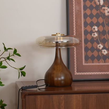 De Pirevo glazen tafellamp is een verfijnde combinatie van glas, messing en hout