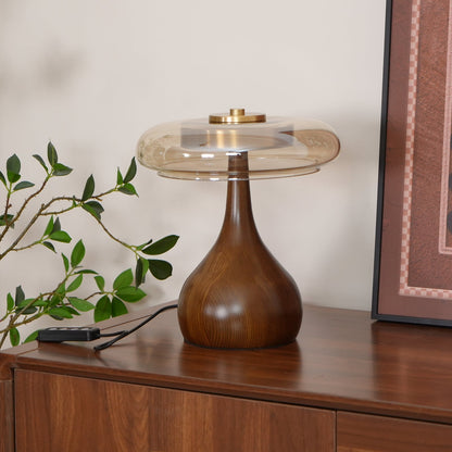 De Pirevo glazen tafellamp is een verfijnde combinatie van glas, messing en hout